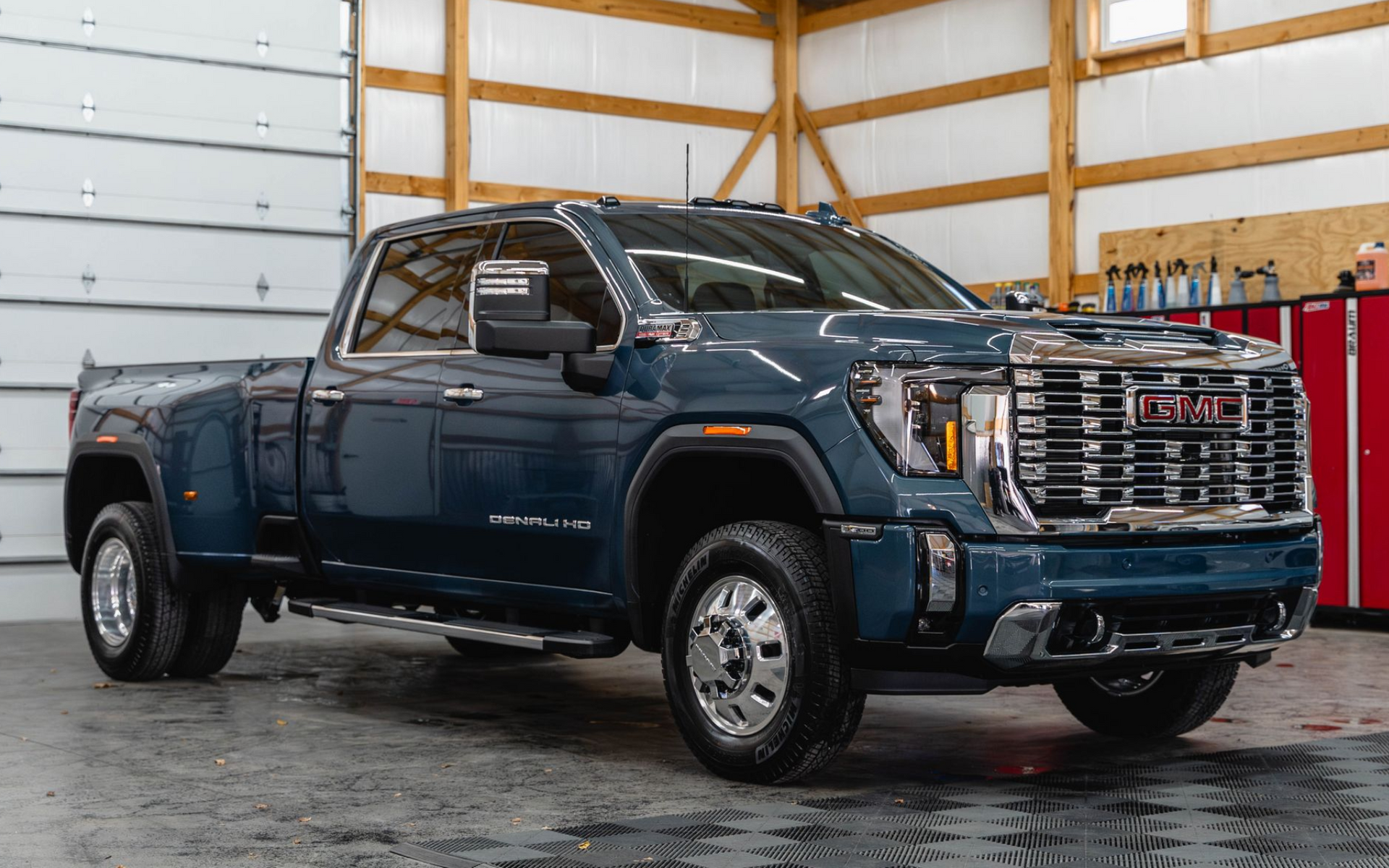 Dark blue GMC Sierra pickup truck parked indoors in a warehouse garage