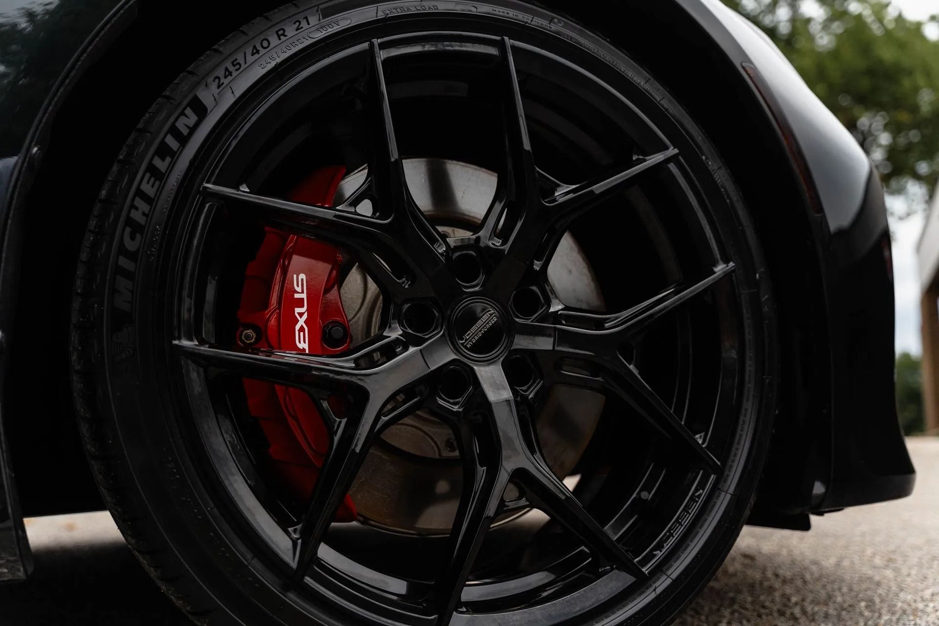 Black sports car wheel with red brake caliper in close-up