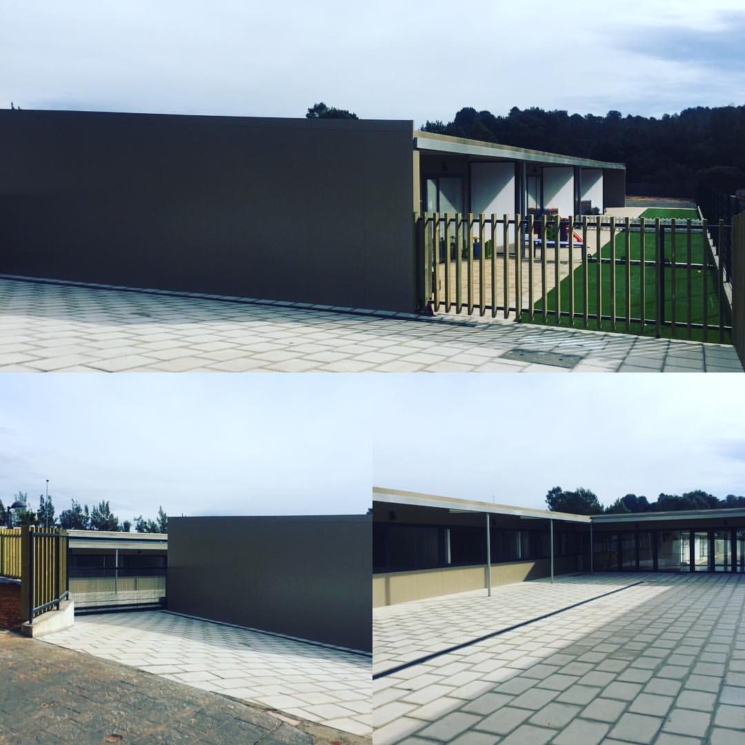 Façana d'una nau industrial amb tancament metàl·lic i zona de despatxos tècnics