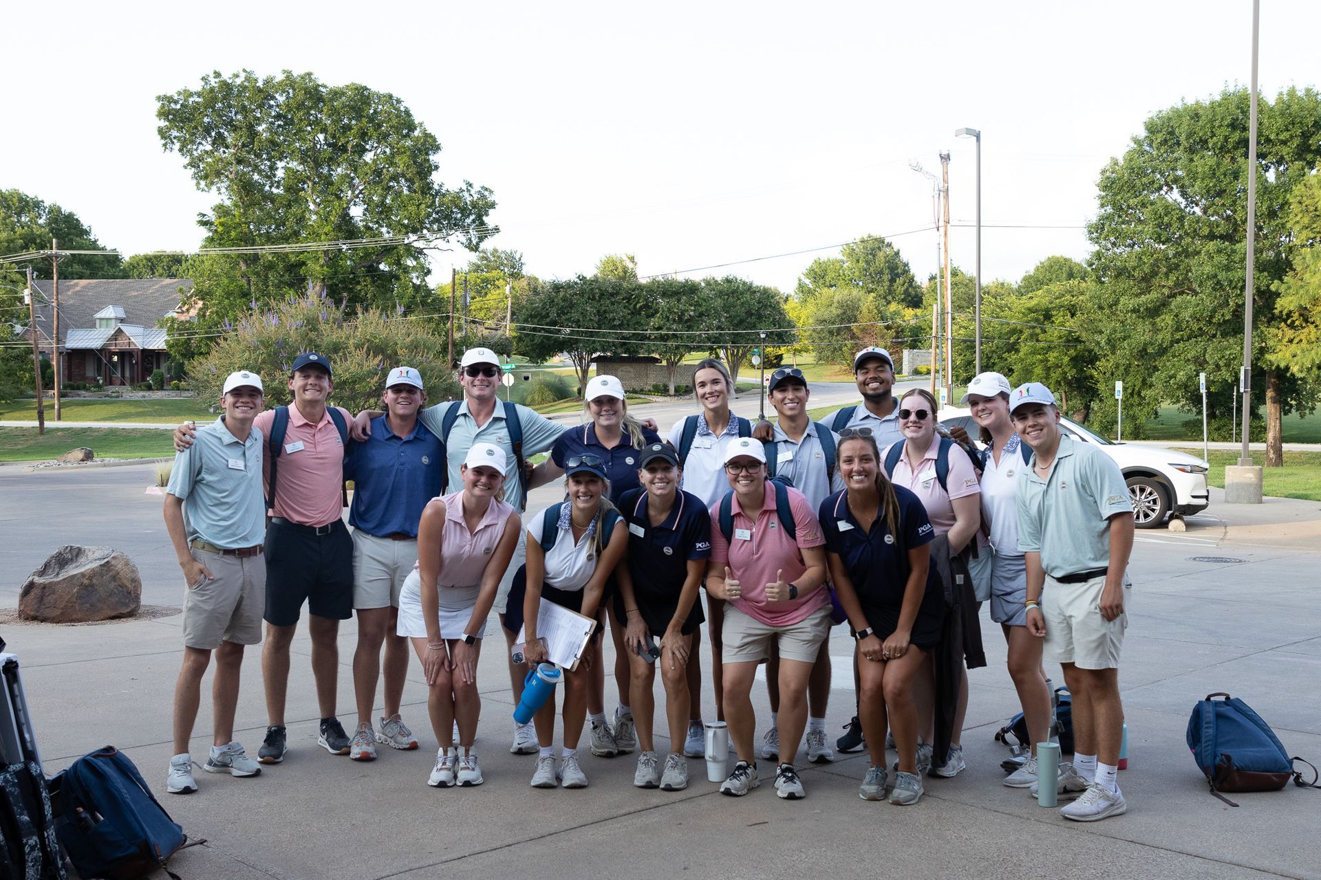 Group of hikers posing together outdoors in a park, with backpacks and walking poles.