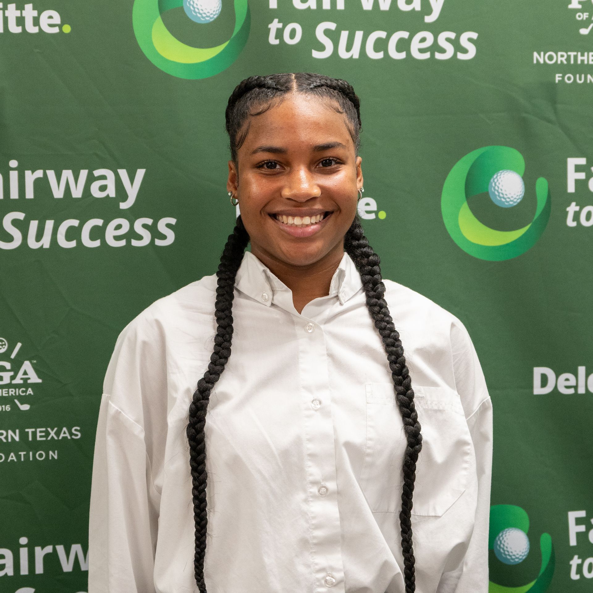 Smiling person in a white shirt standing before a green Fairway to Success backdrop