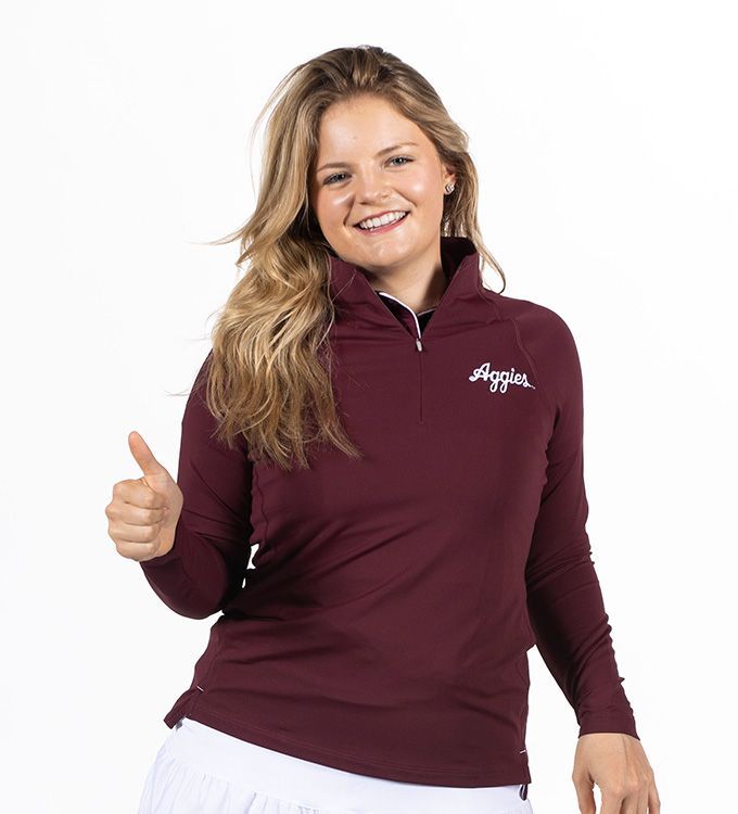 Smiling woman in maroon quarter-zip top giving a thumbs-up on a white background