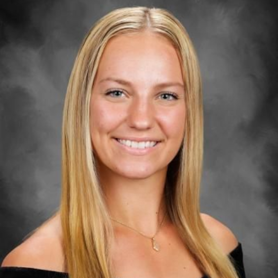 Smiling blonde woman in a black off-shoulder top against a gray studio backdrop