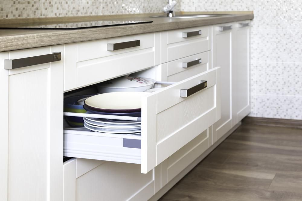 A Kitchen with White Cabinets and A Drawer Filled with Plates — Smith's Joinery in Bangalow, NSW