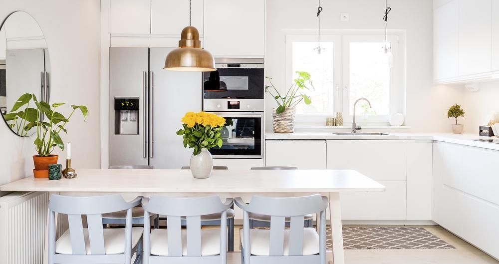 A Kitchen with White Cabinets, Stainless Steel Appliances, a Table and Chairs — Smith's Joinery in Evans Head, NSW