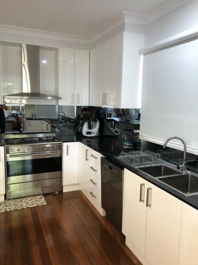 A Kitchen with Stainless Steel Appliances and White Cabinets — Smith's Joinery in Bangalow, NSW