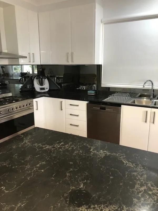 A Kitchen with Black Counter Tops, White Cabinets, a Stove and A Sink — Smith's Joinery in Tabulam, NSW