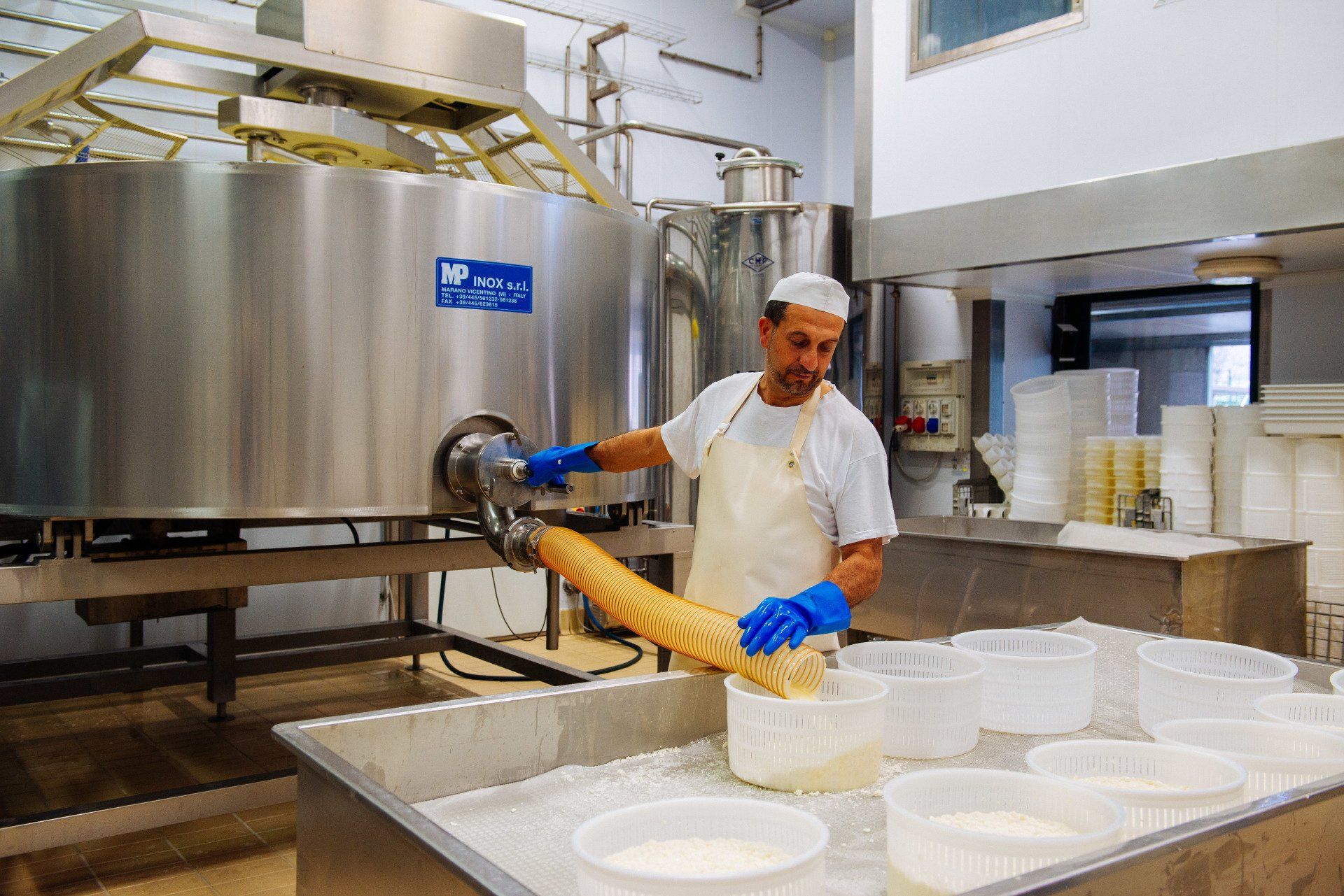 Un uomo sta producendo formaggio in una fabbrica.