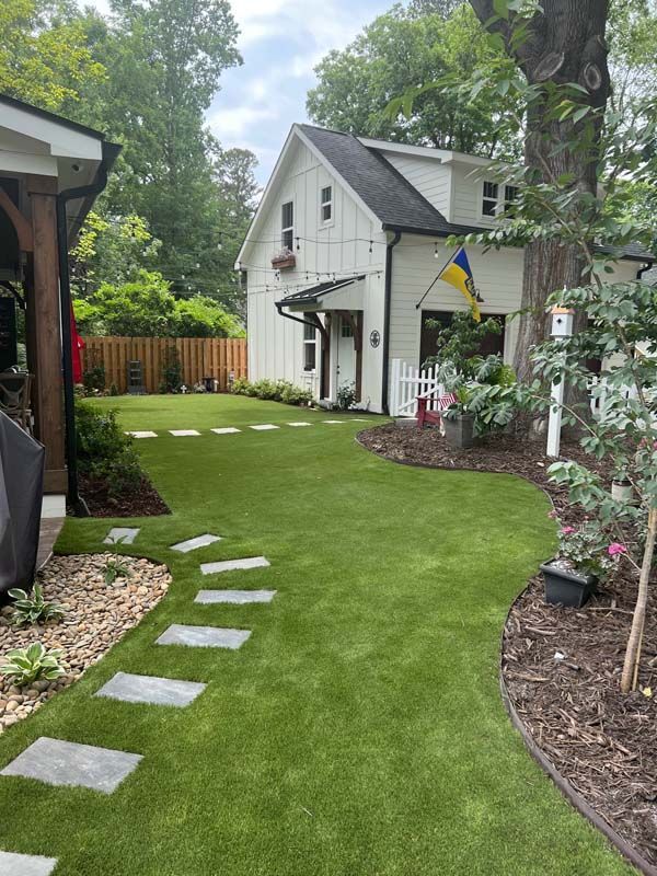 A white house with a lush green lawn in front of it.