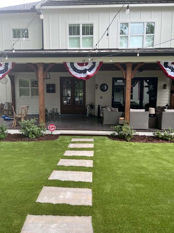 A house with a covered porch and a walkway leading to it.