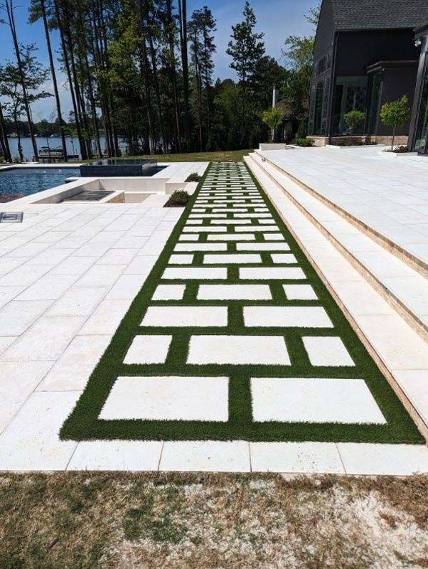A brick walkway with grass on the side of it