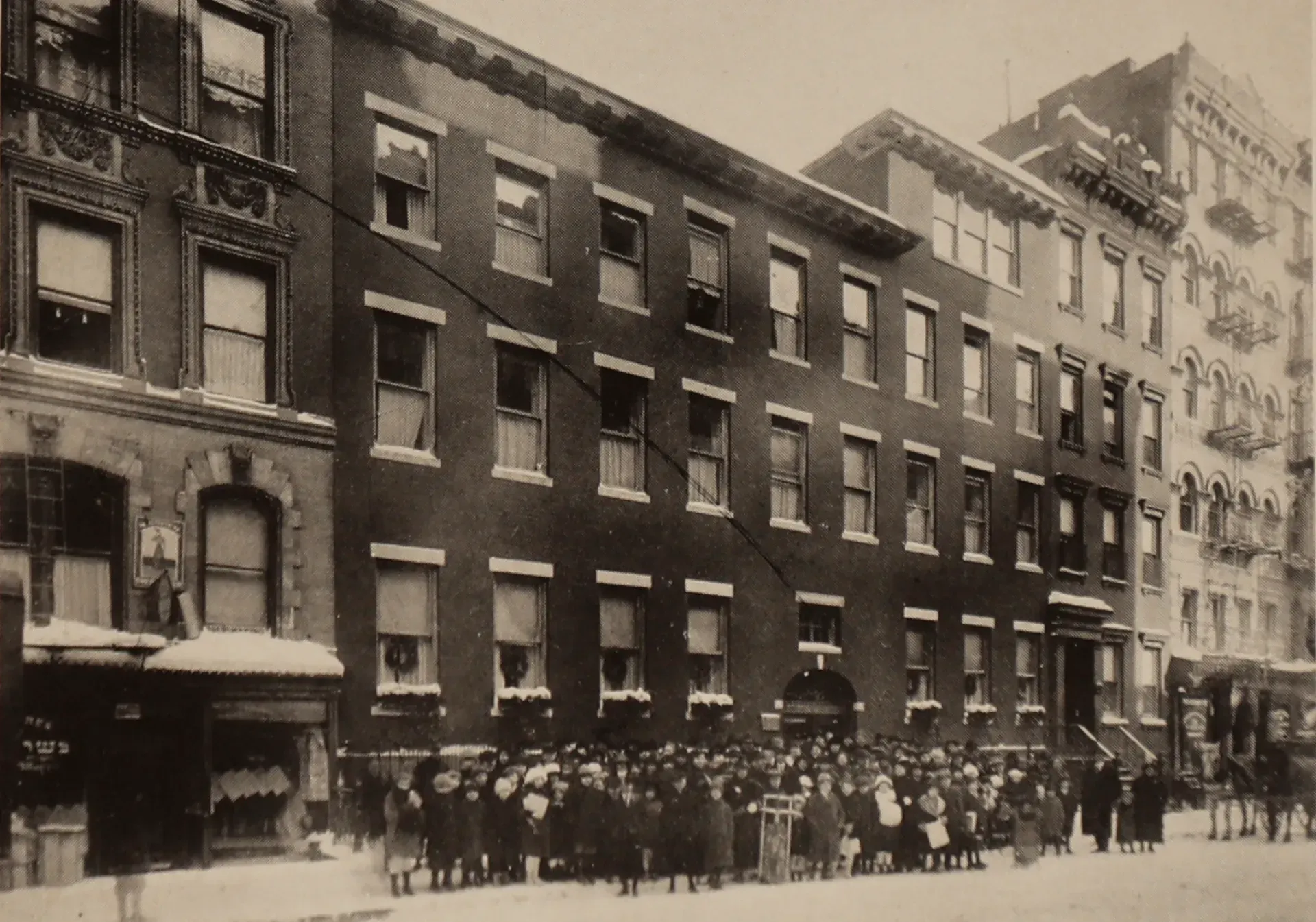 A black and white photo of a row of brick buildings