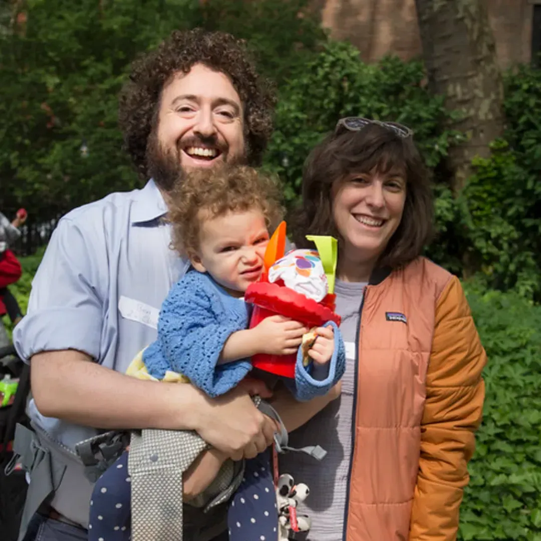 A man and woman are holding a baby in their arms