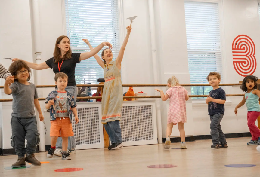 A group of children are dancing in a dance studio.