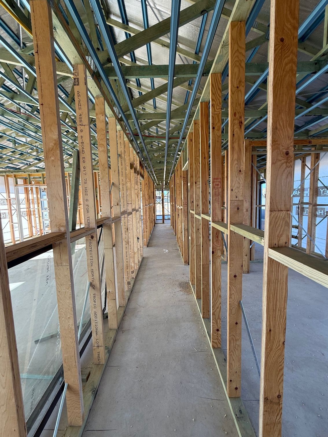 A long wooden hallway in a building under construction.