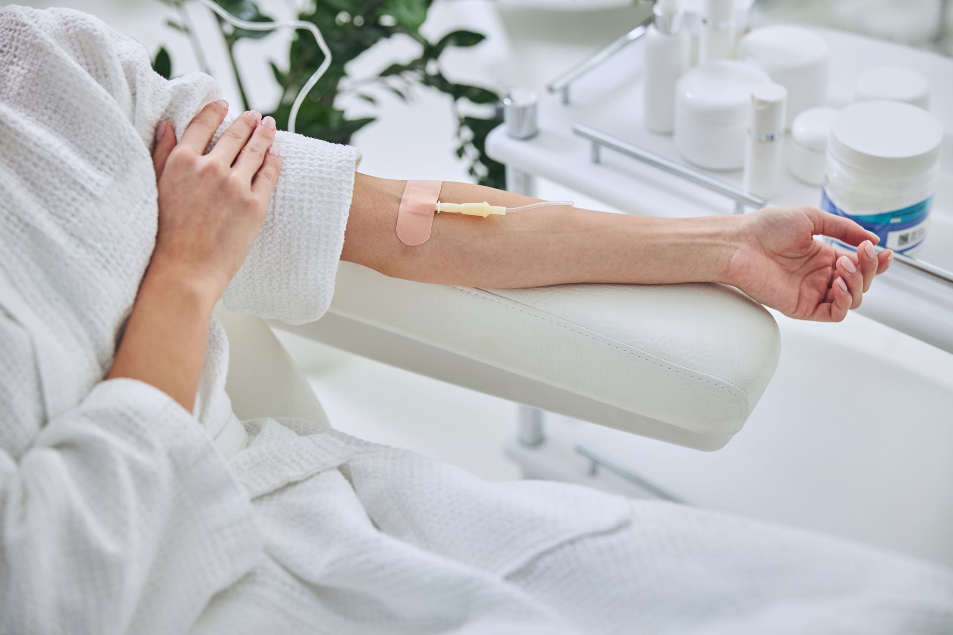 A woman is sitting in a chair with an iv in her arm.