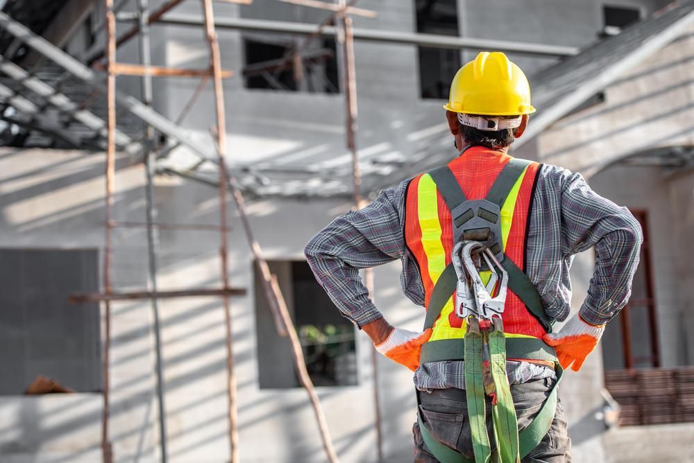 A Construction Worker Wearing a Hard Hat and Safety Harness — Formosa Building And Renovations in Kensington, QLD