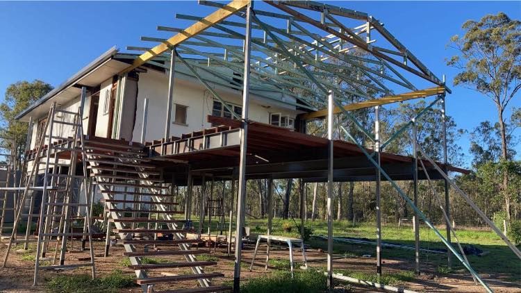 A House Is Being Built on Stilts with Scaffolding Around It — Formosa Building And Renovations in Childers, QLD