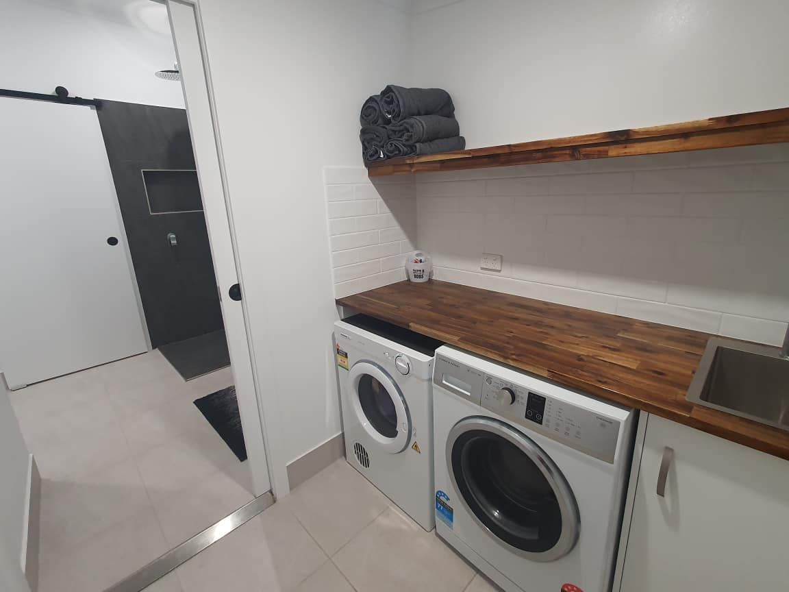 A Laundry Room with A Washer and Dryer and A Sink — Formosa Building And Renovations in Childers, QLD