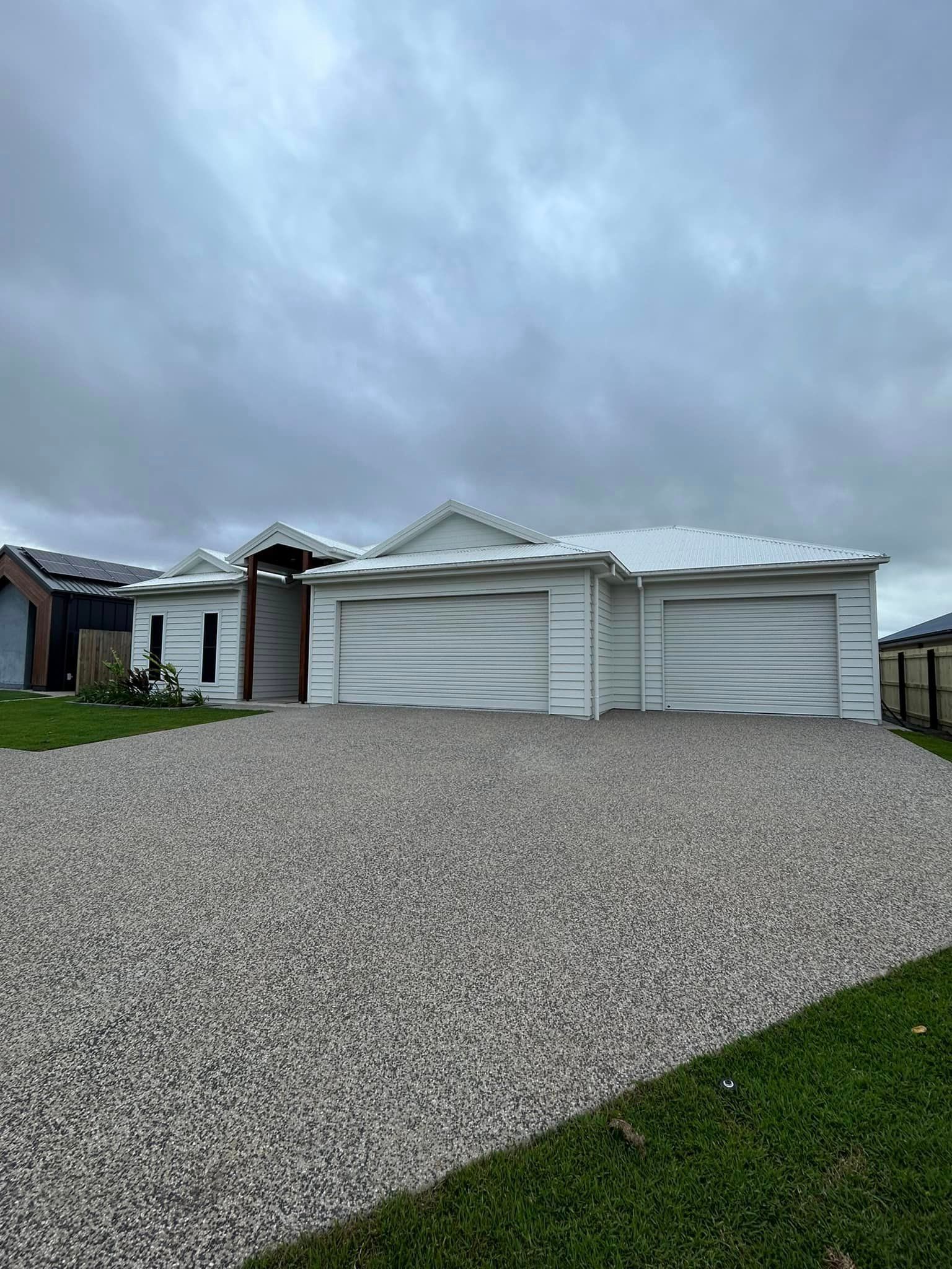A Large White House with A Gravel Driveway in Front of It — Formosa Building And Renovations in Childers, QLD