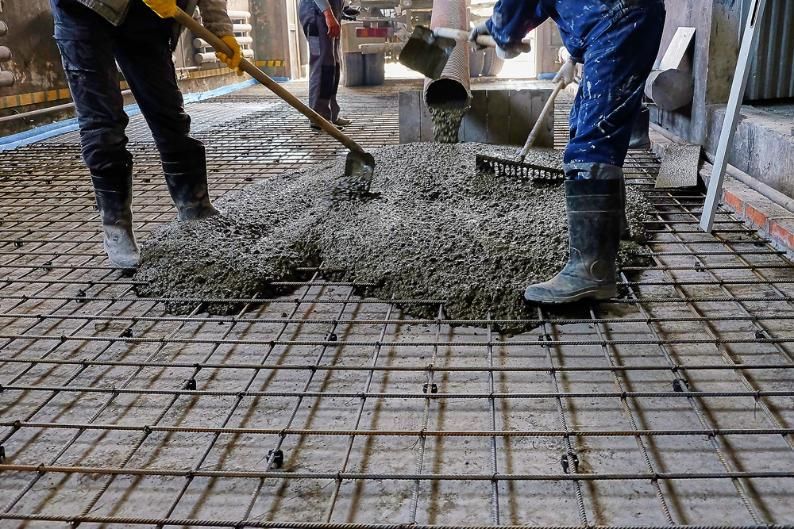 A Couple of Construction Workers Are Pouring Concrete — Formosa Building And Renovations in Kensington, QLD