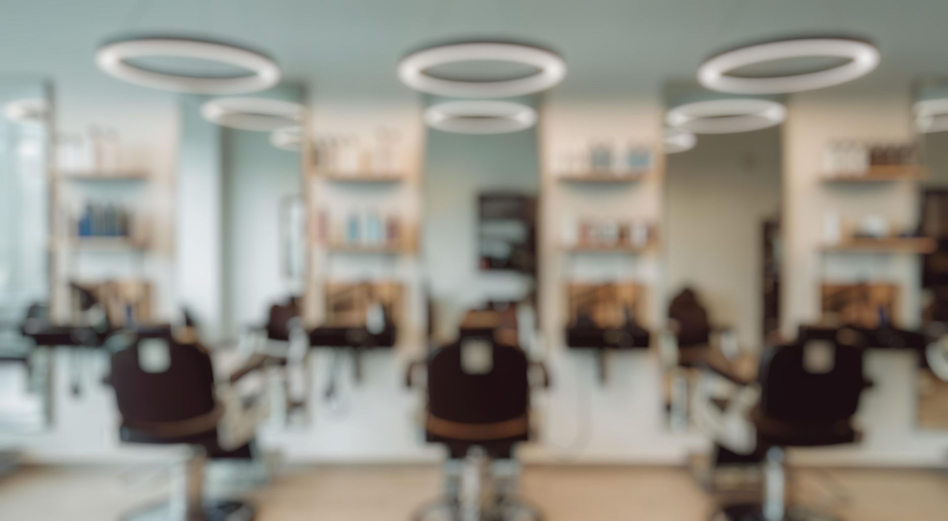 Modern hair salon interior with styling chairs, mirrors, and circular ceiling lights