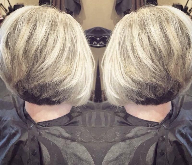 Mirrored photo of a blonde layered bob haircut with dark underlayers, shown from the back on both sides