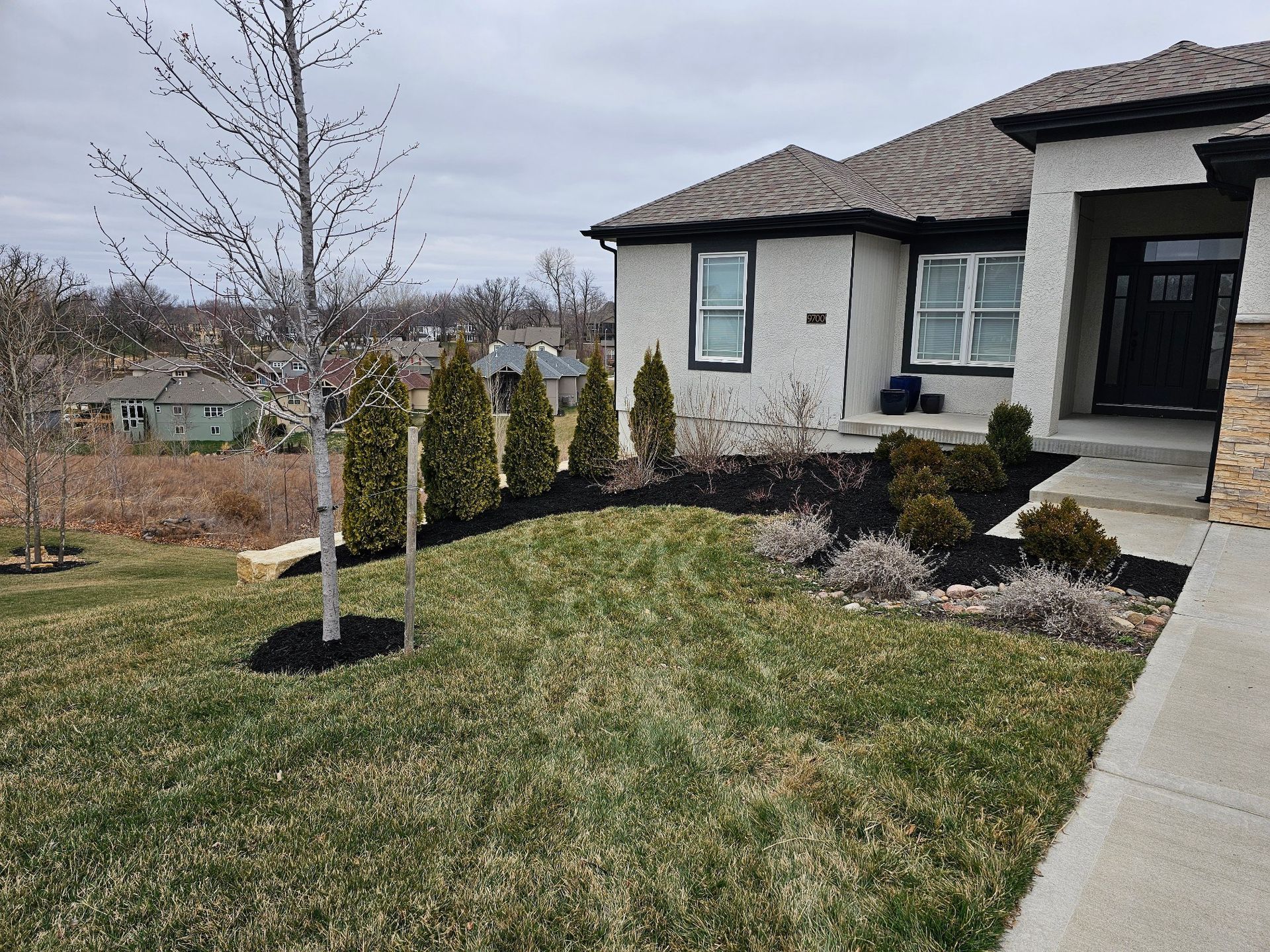 Decorative river rock accents placed along a healthy, well-maintained lawn