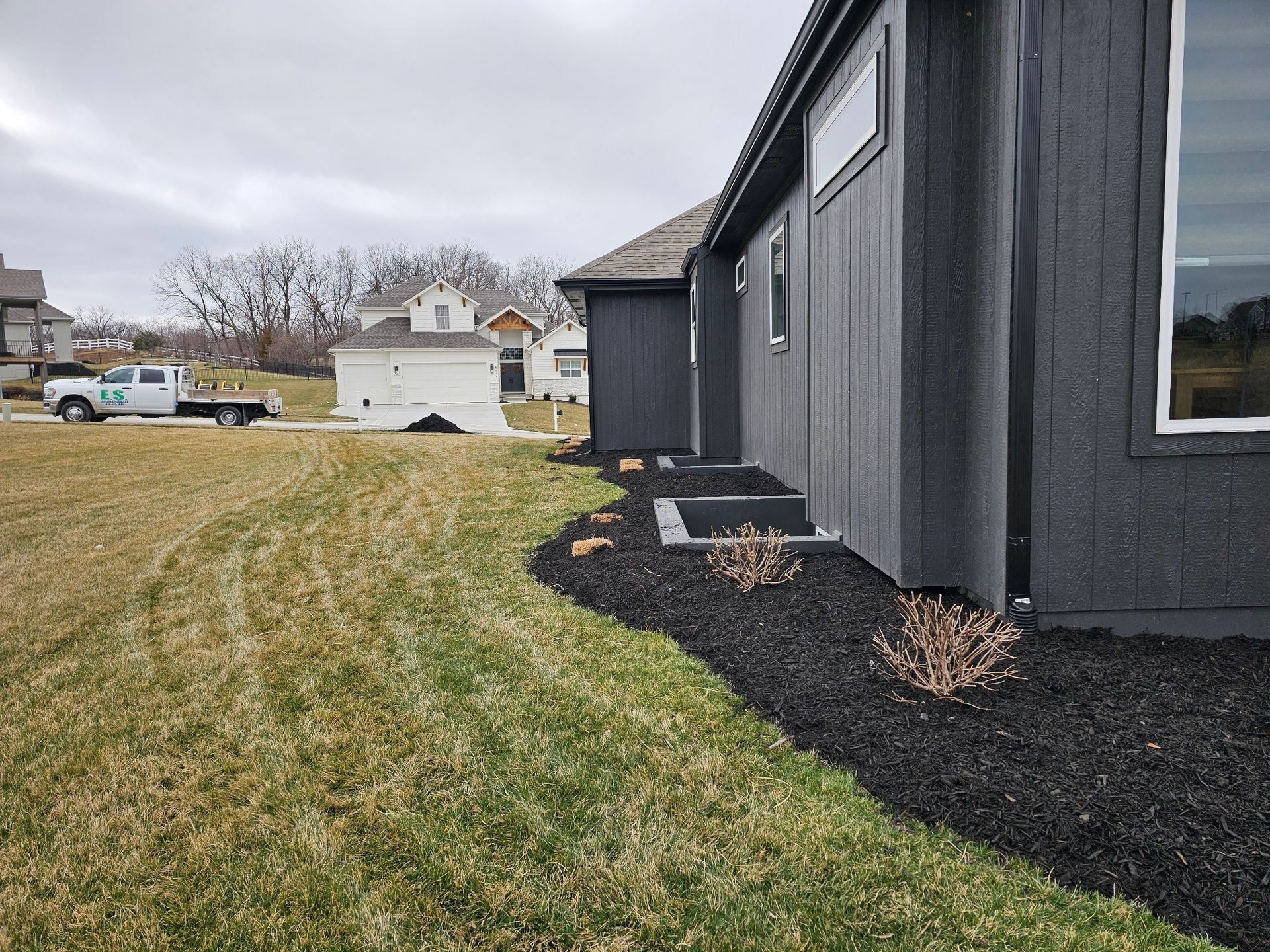 Neatly mowed grass surrounding a stone pathway and mulched planting beds