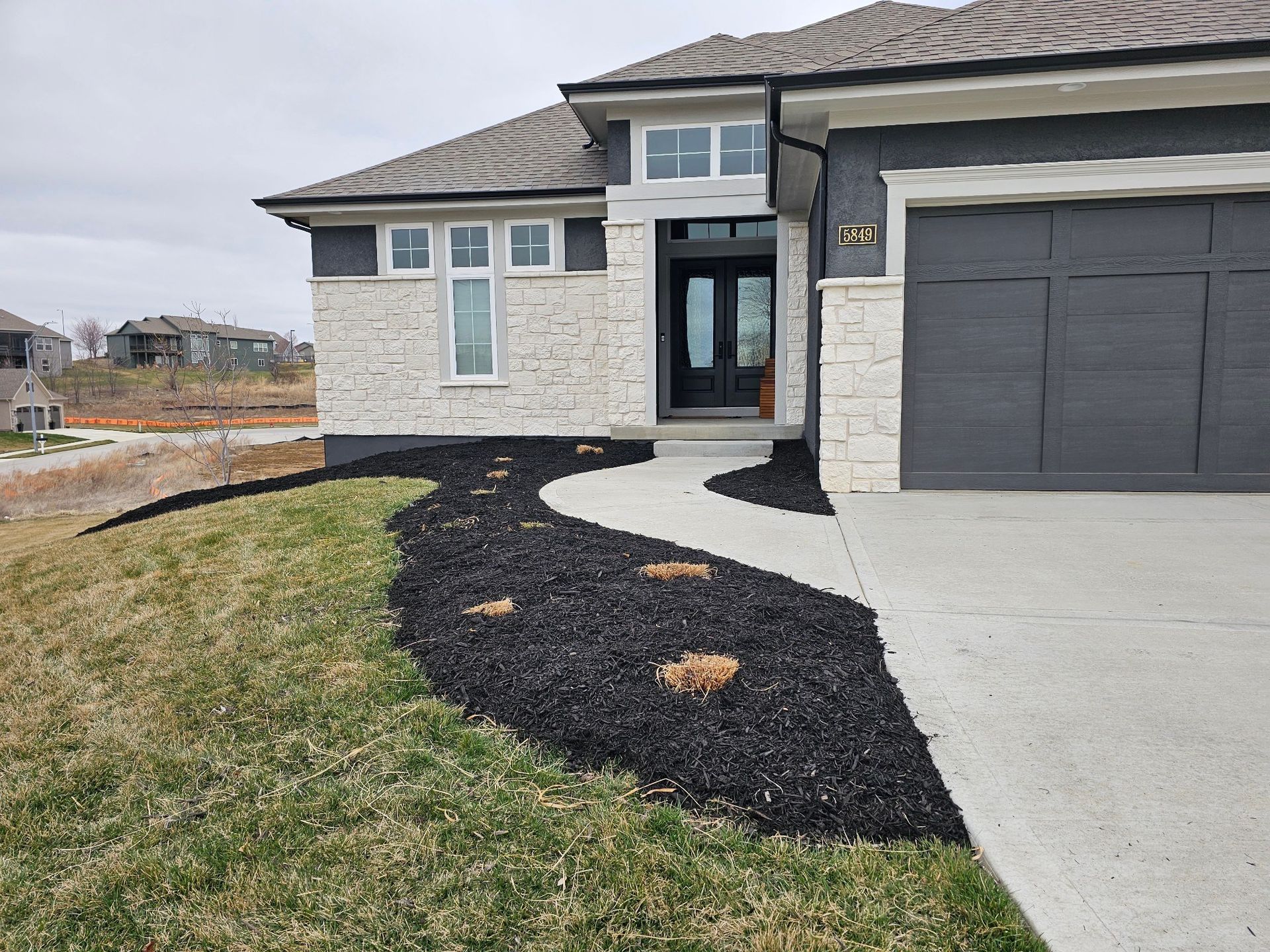 Lawn care experts improving turf health around rock and mulch landscapes