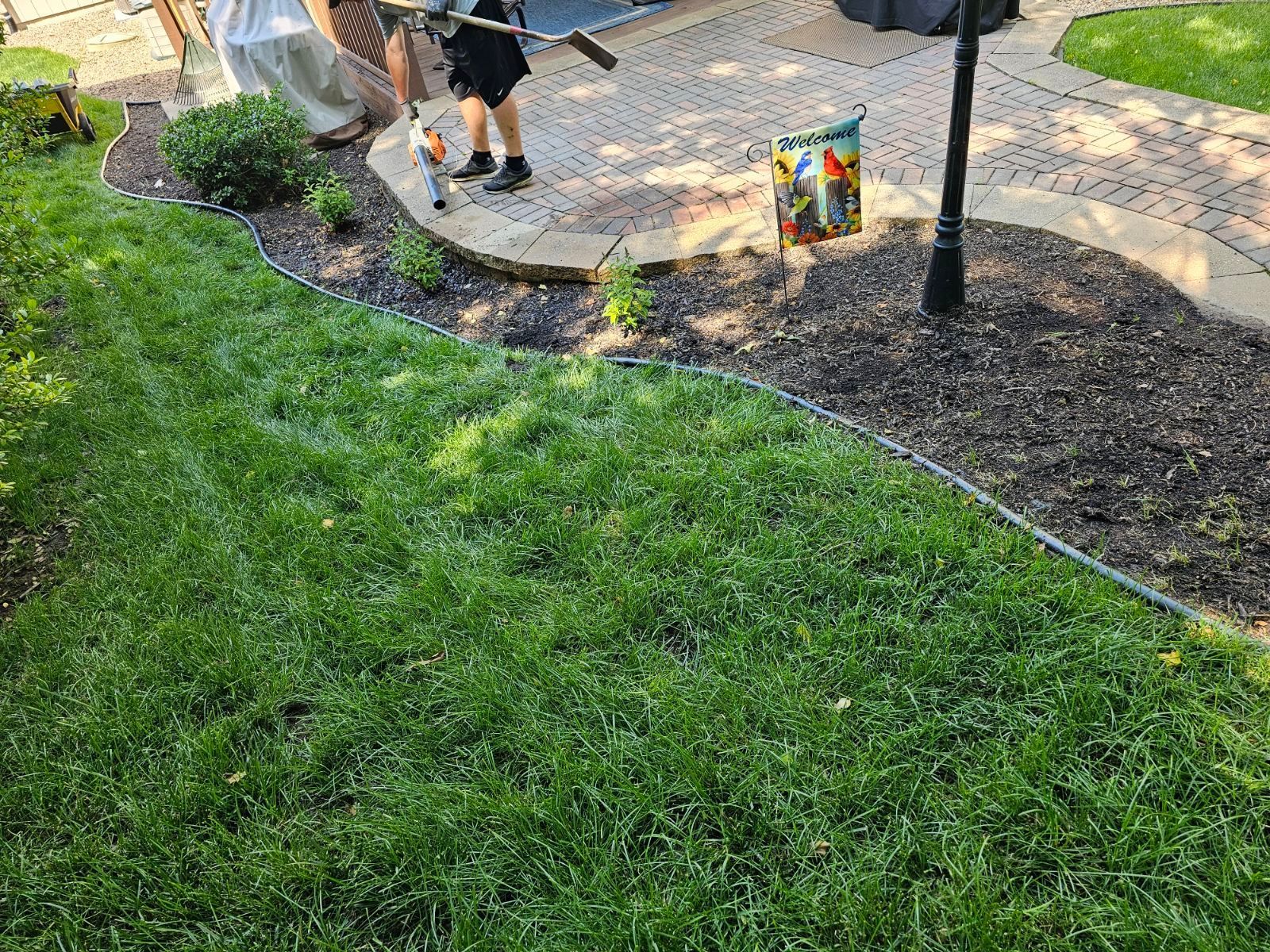 Rock mulch bed highlighting neatly maintained grass and trimmed hedges