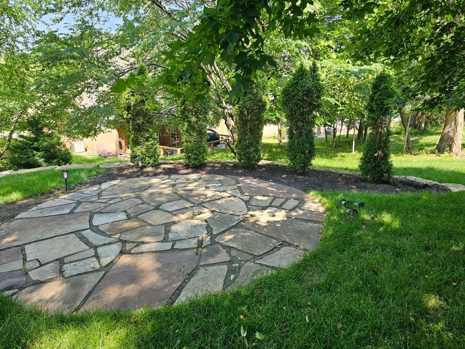 Well-trimmed lawn with rock edging separating grass from garden beds
