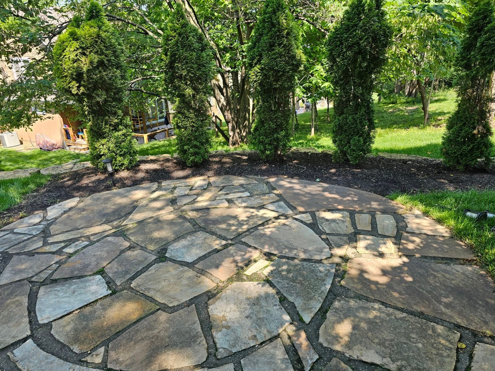 Clean green lawn surrounded by decorative landscaping rocks and plants