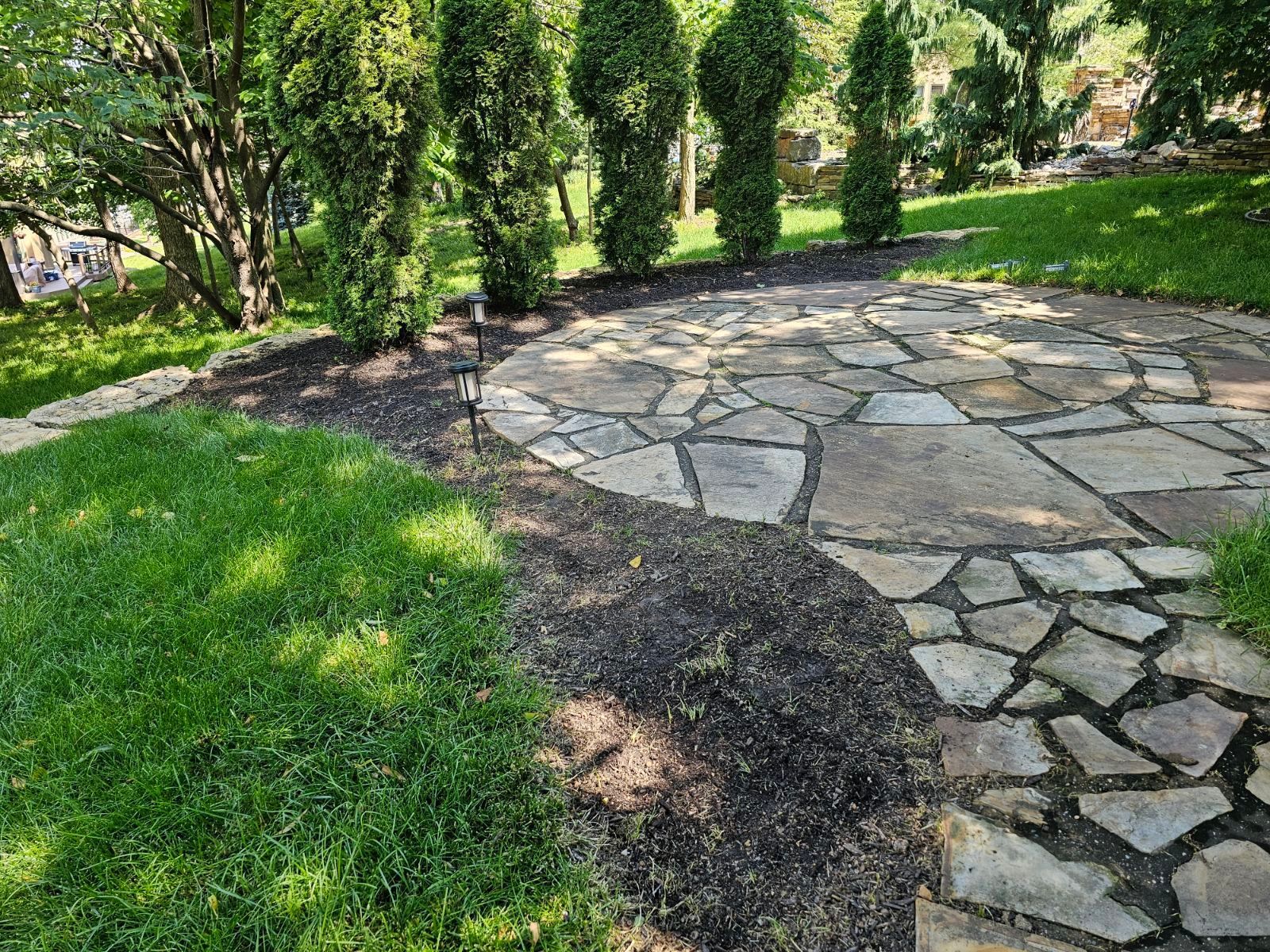 Rock garden integrated into a well-kept lawn with neatly trimmed edges