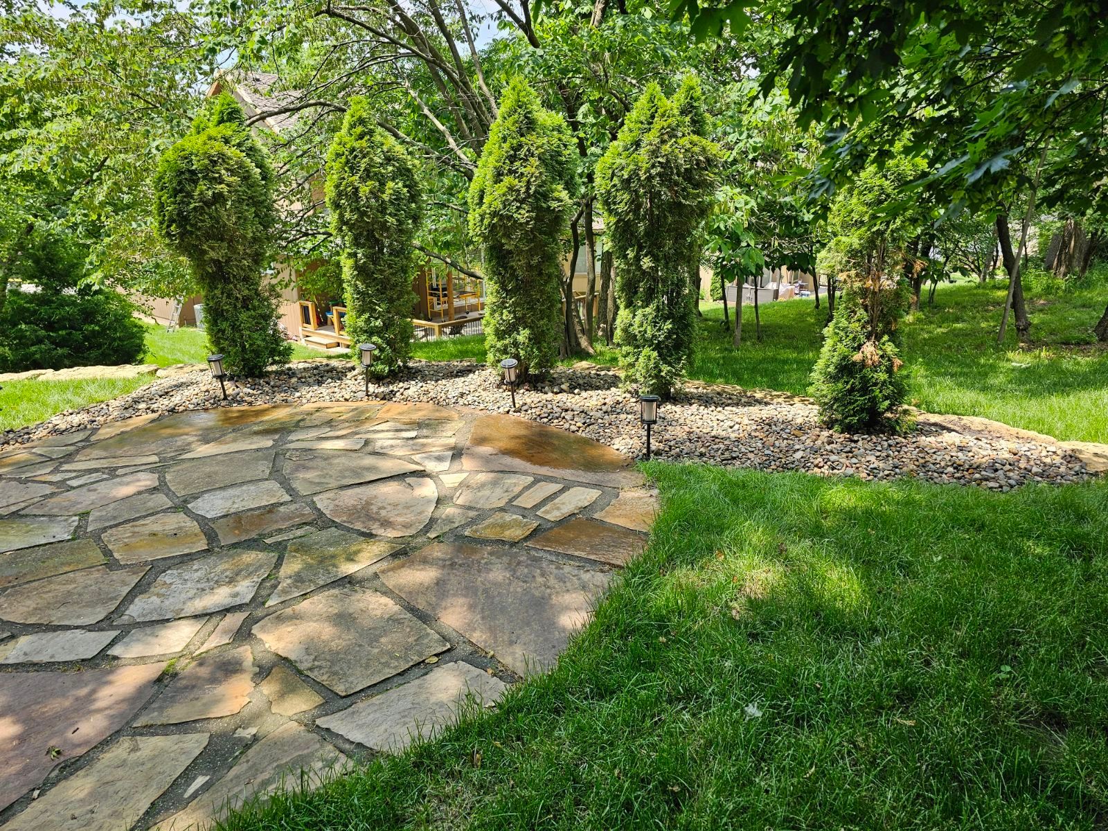 Close-up of grass meeting decorative stones in a professionally landscaped yard