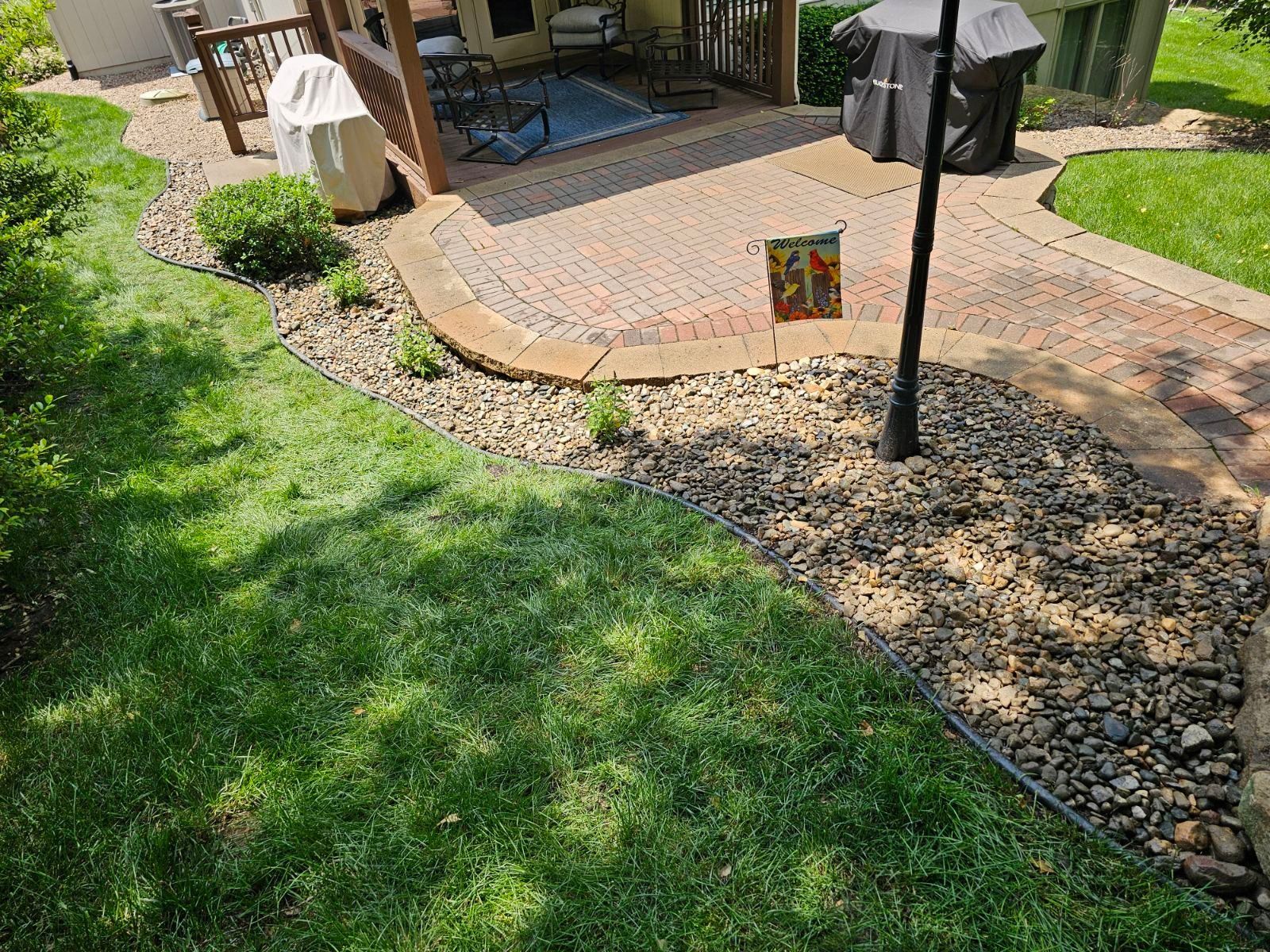 Freshly edged lawn with decorative rock borders outlining the landscape beds