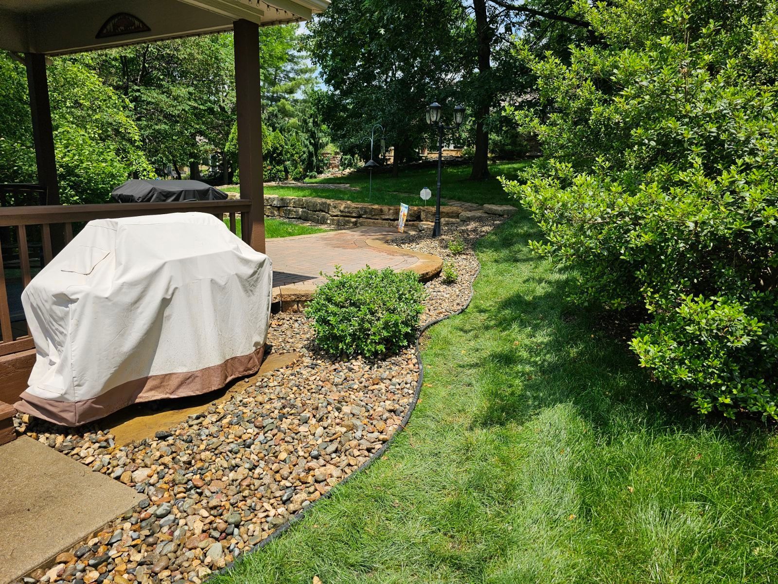 Front yard makeover featuring updated mulch, rock features, and healthy turf