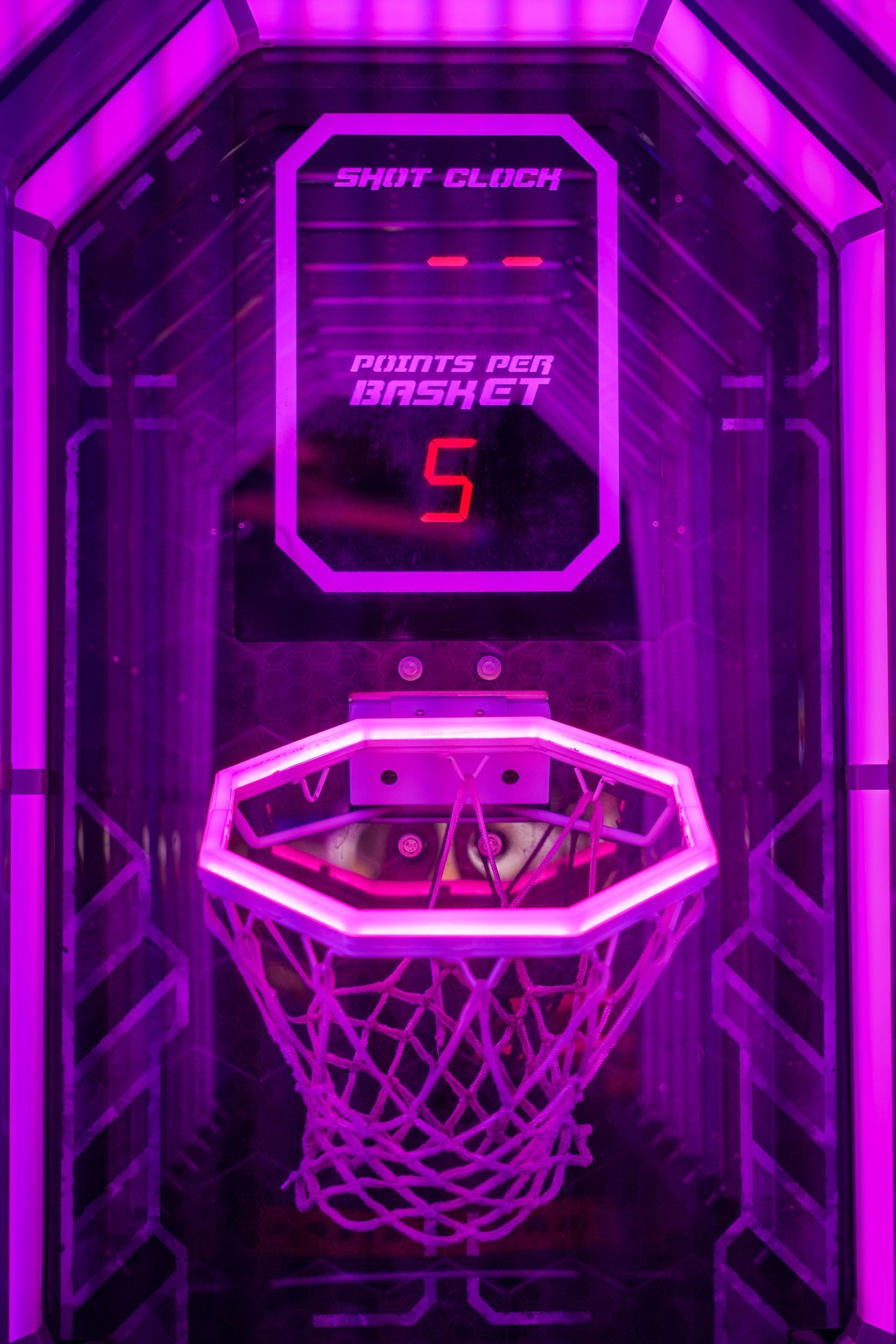 Purple-lit arcade basketball hoop with digital score display showing 5 points.