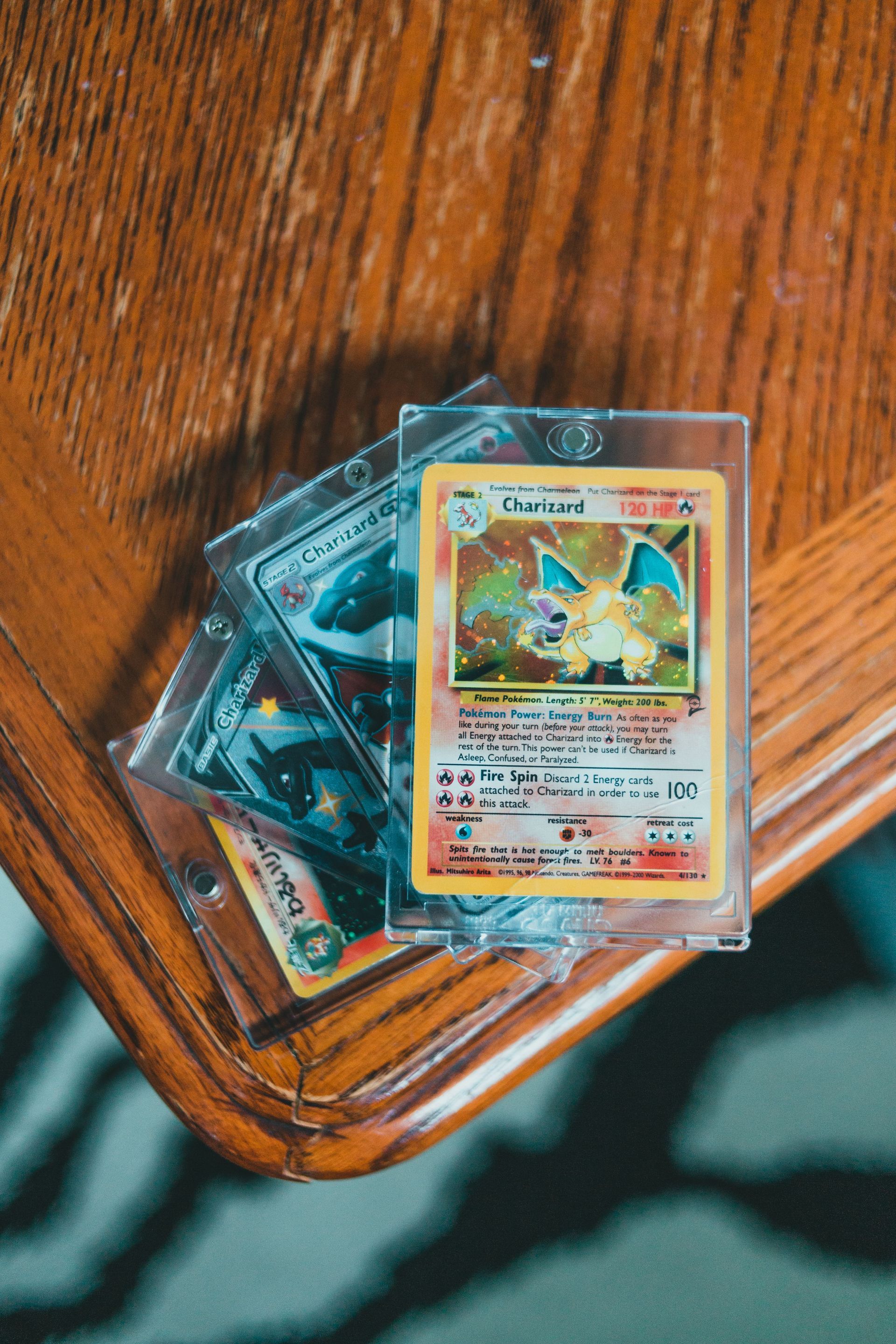 Several trading cards on a wooden table, with one holographic card on top.