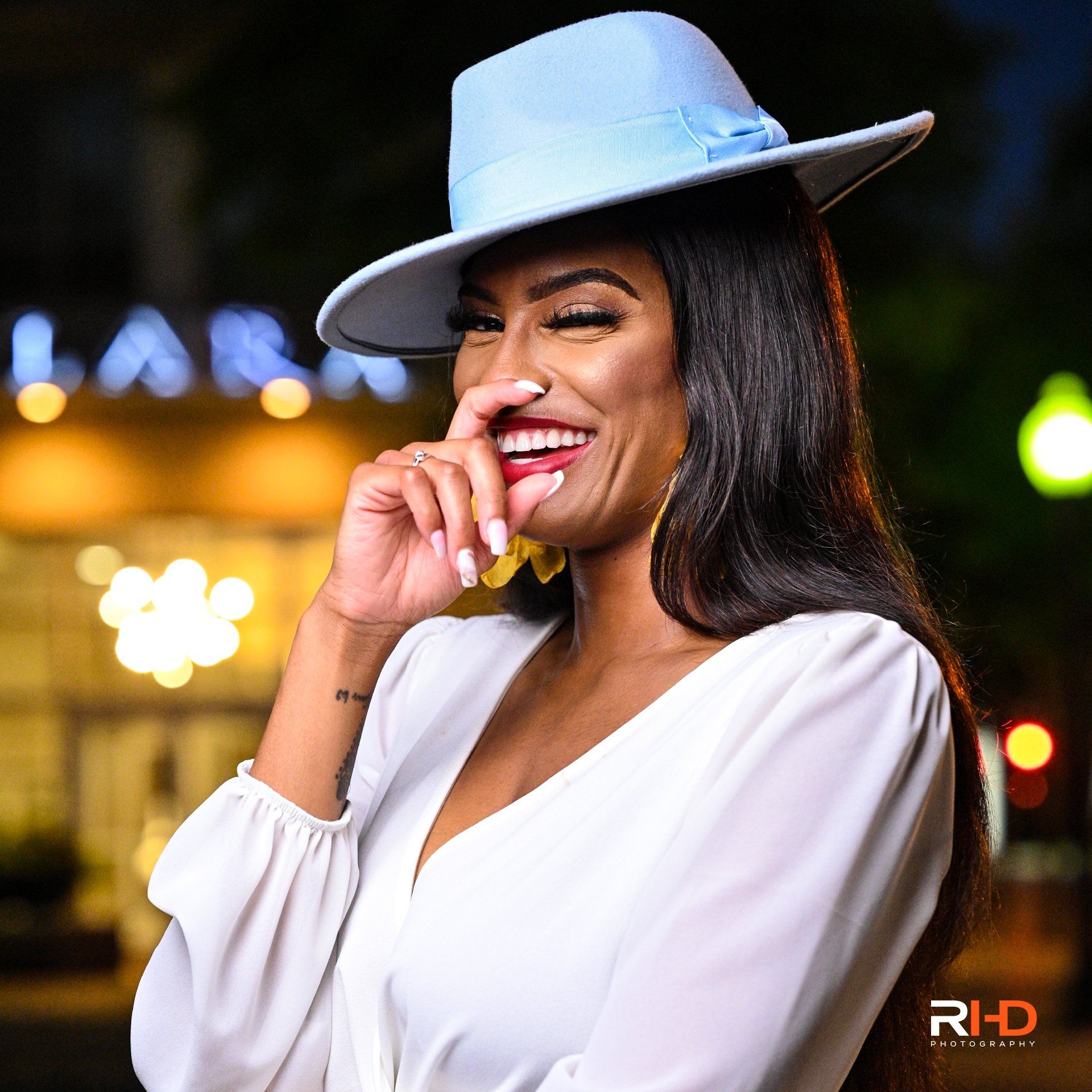 a woman wearing a blue hat and a white shirt is smiling .