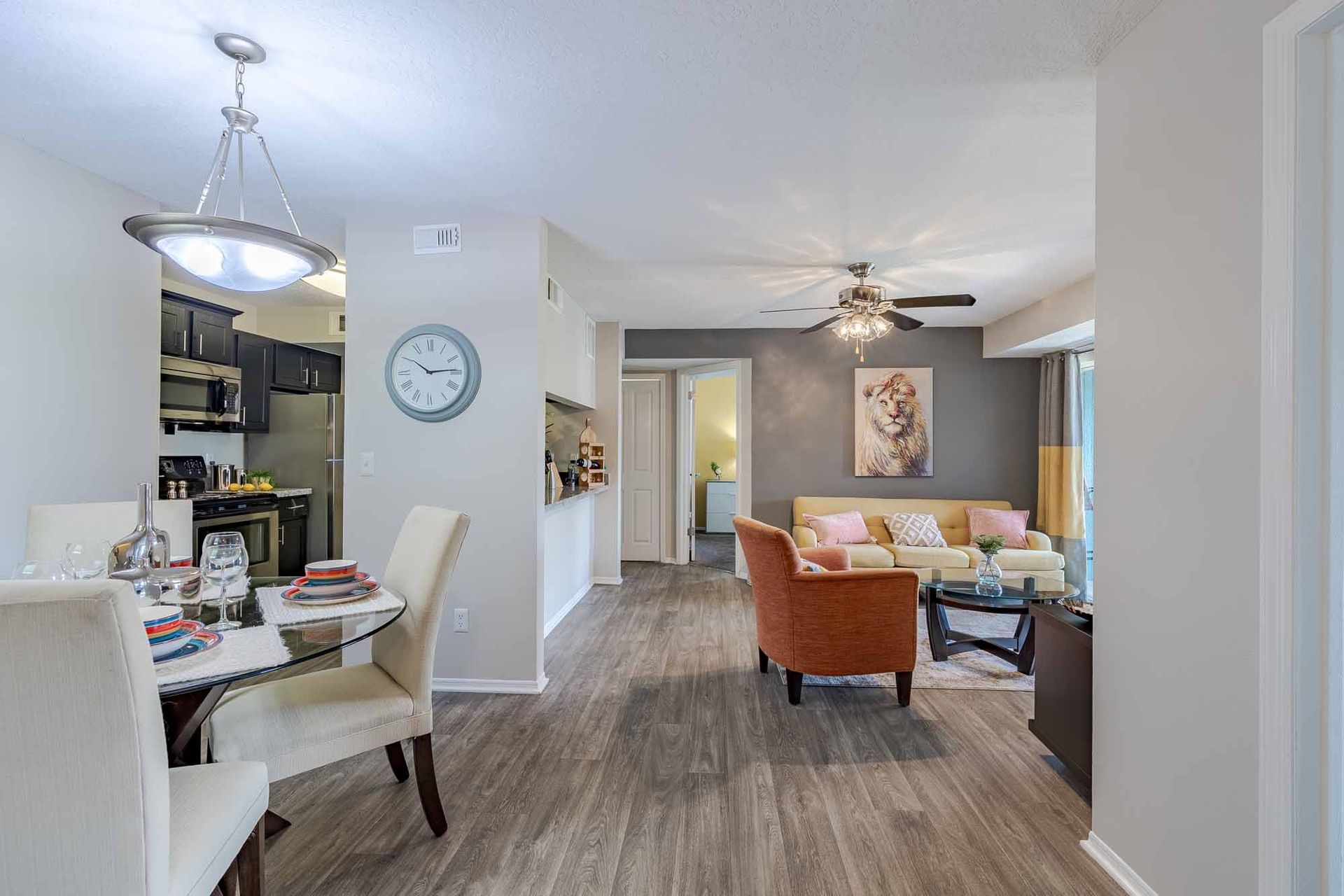 Open-concept living space with dining area, living room, and a peek into the kitchen and bedroom. Tour these exceptional Melbourne, FL apartments and experience Savannahs at James Landing firsthand.