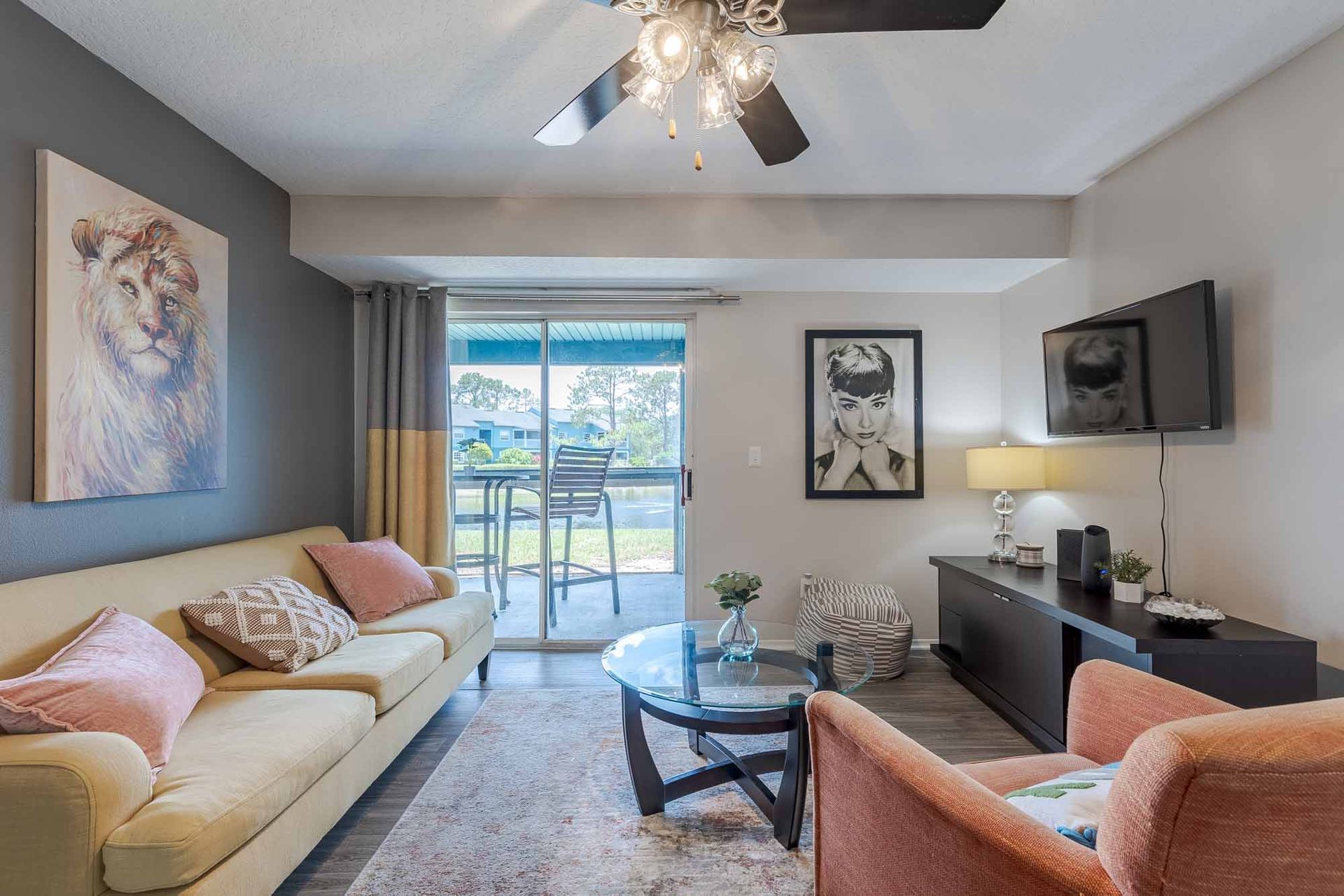 Cozy living room with a beige couch, art, and a sliding glass door to a patio. See what makes these Melbourne, FL apartments for rent stand out by booking your private tour.