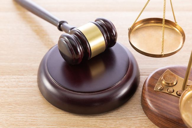 A judge 's gavel and scales of justice on a wooden table