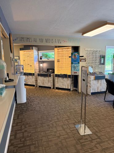 Library front desk with computers, bright bulletin boards, and carpeted interior.