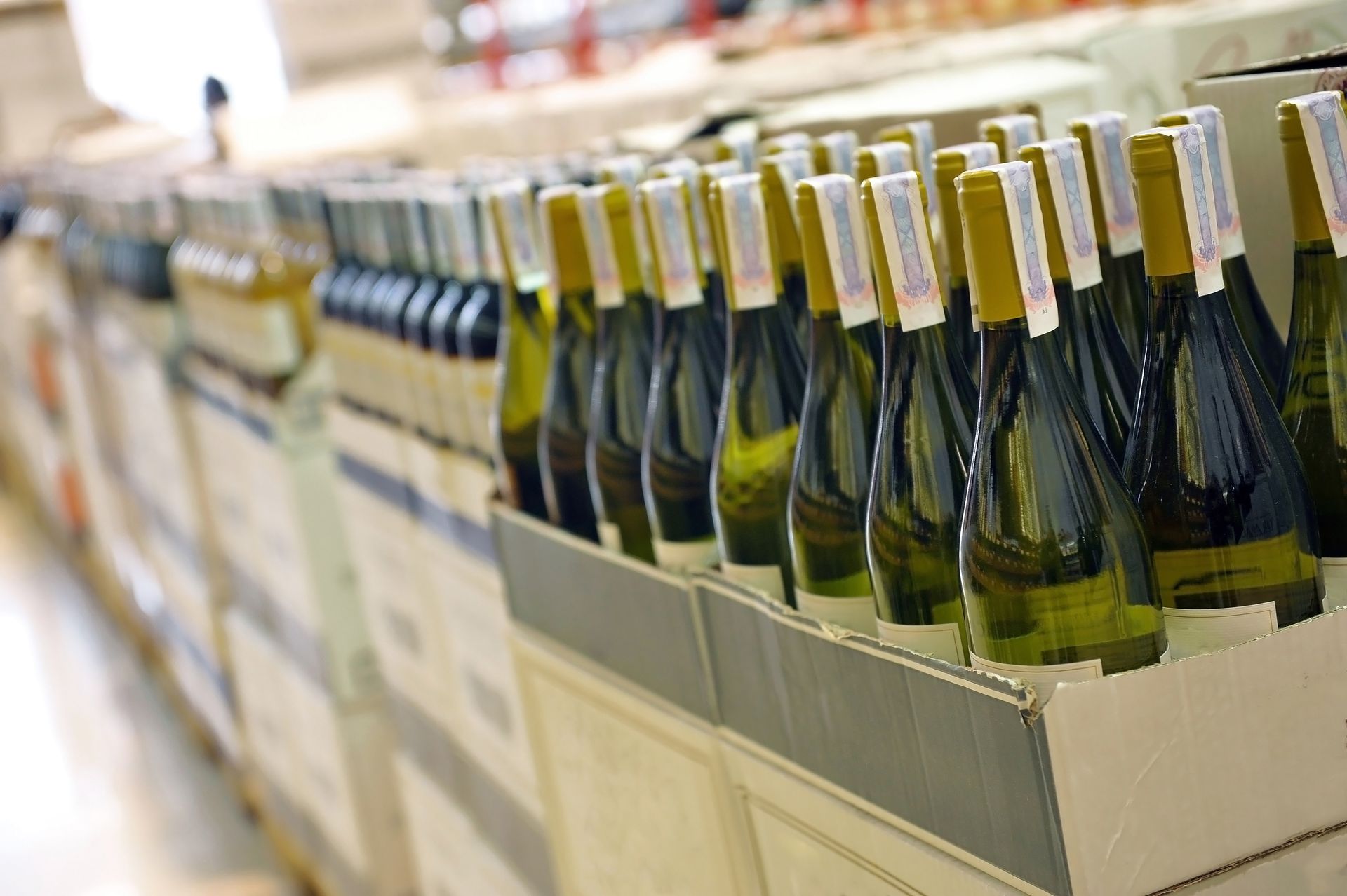 Rows of champagne bottles in a store display, seen in perspective on a shelf. Rows of champagne bottles in a store display, seen in perspective on a shelf.