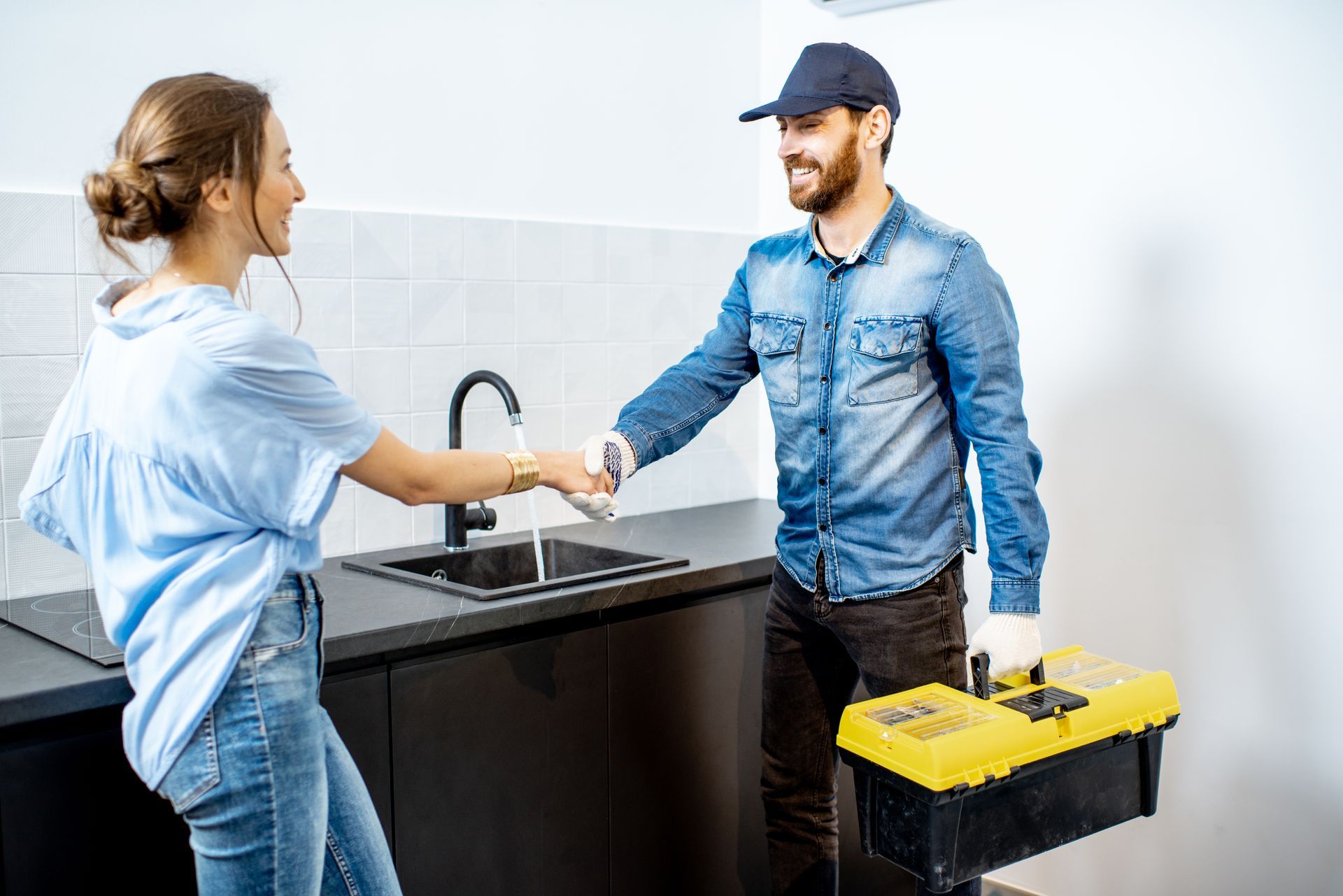 plumber in kitchen with client