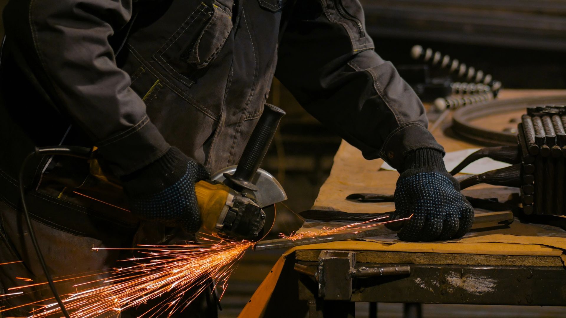 Un herrero suelda una verja metálica decorativa en su taller