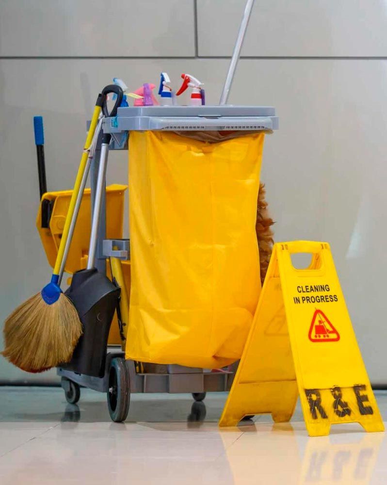 Yellow cleaning cart with supplies next to 