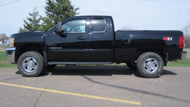Black pickup truck parked in a lot, side view.
