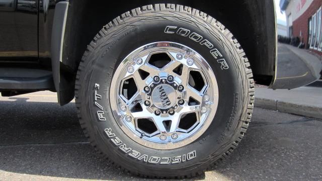 Close-up of a truck tire and chrome wheel on pavement